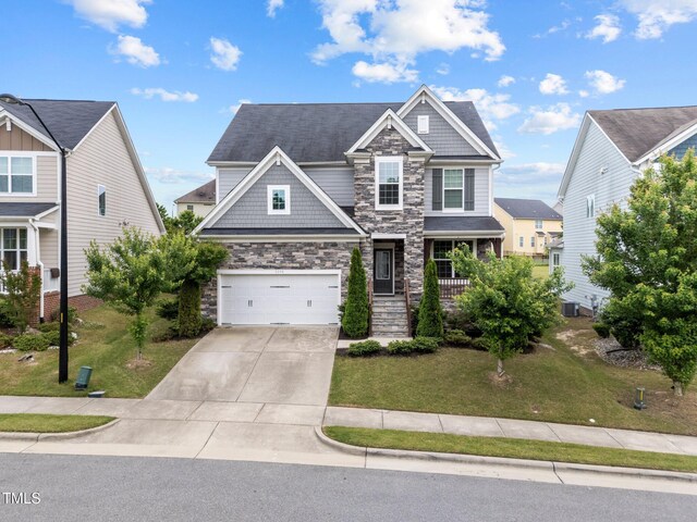 craftsman inspired home featuring stone siding, a garage, driveway, and a front yard
