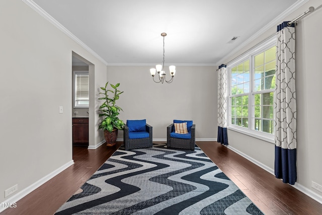 living area with wood finished floors, a chandelier, ornamental molding, and baseboards