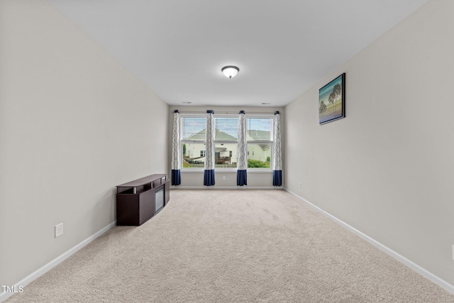 carpeted empty room with baseboards