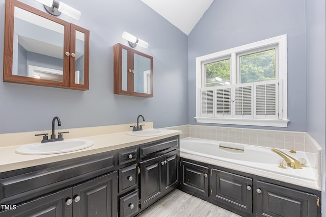 105 Houston Cir, Cary, NC 27513 - bathroom featuring lofted ceiling, double vanity, a bath, and wood finished floors