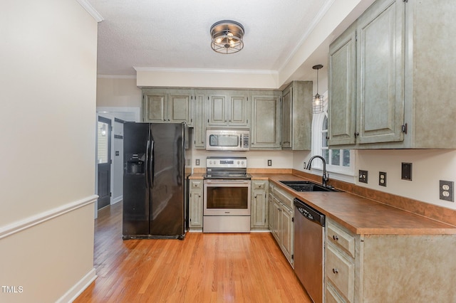 105 Houston Cir, Cary, NC 27513 - kitchen featuring stainless steel appliances, a sink, light wood-style floors, dark countertops, and ornamental molding