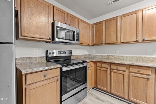 kitchen with stainless steel appliances and light wood finished floors