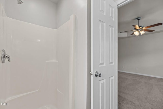 bathroom with ceiling fan, a shower, and baseboards