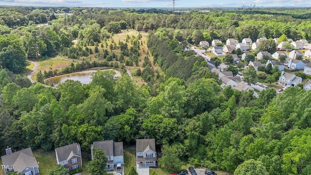 aerial view of property's location with a heavily wooded area, nearby suburban area, and a nearby body of water