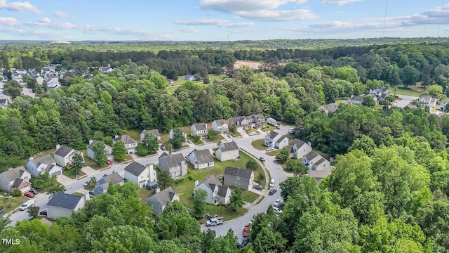 aerial view of property's location with a heavily wooded area and nearby suburban area