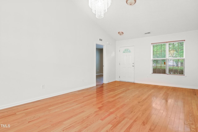 3108 Forrestal Dr, Durham, NC 27703 - unfurnished room with a chandelier, light wood finished floors, baseboards, and high vaulted ceiling