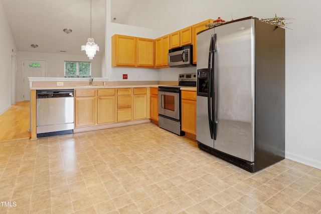3108 Forrestal Dr, Durham, NC 27703 - kitchen featuring appliances with stainless steel finishes, light countertops, a sink, light floors, and a peninsula