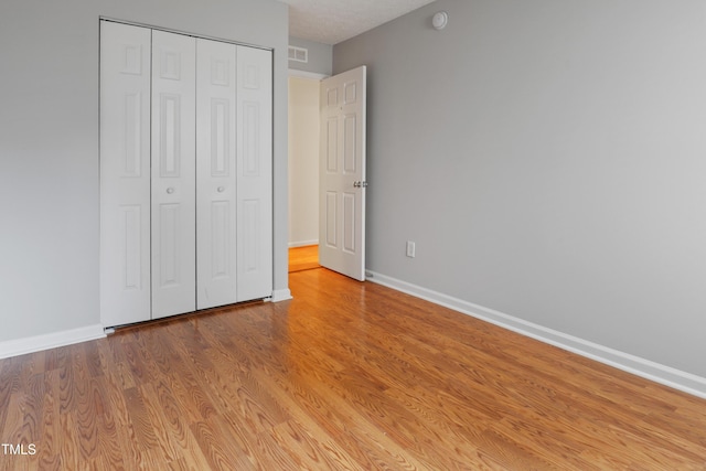 3108 Forrestal Dr, Durham, NC 27703 - unfurnished bedroom with baseboards, a closet, and wood finished floors
