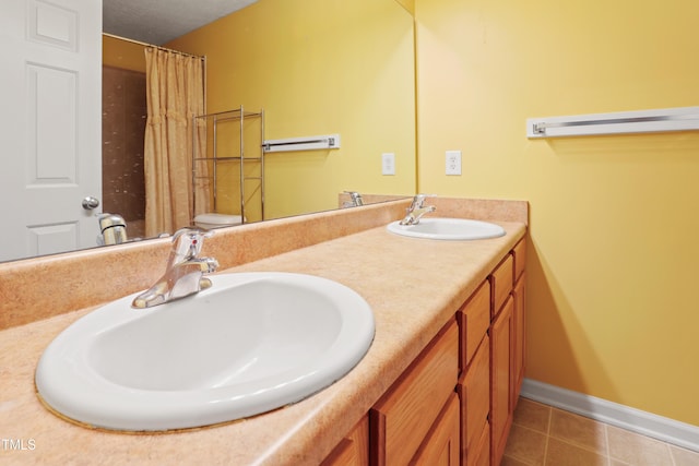 3108 Forrestal Dr, Durham, NC 27703 - bathroom featuring tile patterned floors, baseboards, double vanity, and a shower with shower curtain