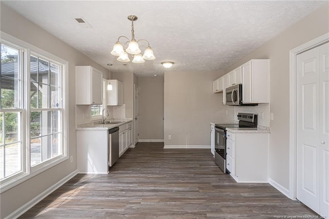 551 Hobson Rd, Raeford, NC 28376 - kitchen featuring stainless steel appliances, a sink, a chandelier, dark wood-style flooring, and a textured ceiling