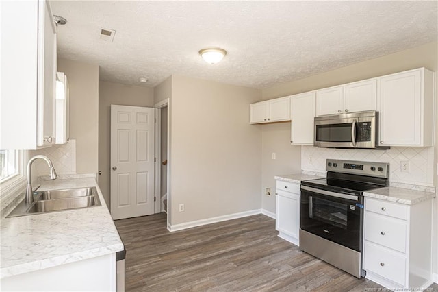 551 Hobson Rd, Raeford, NC 28376 - kitchen with appliances with stainless steel finishes, a sink, dark wood-type flooring, white cabinetry, and a textured ceiling