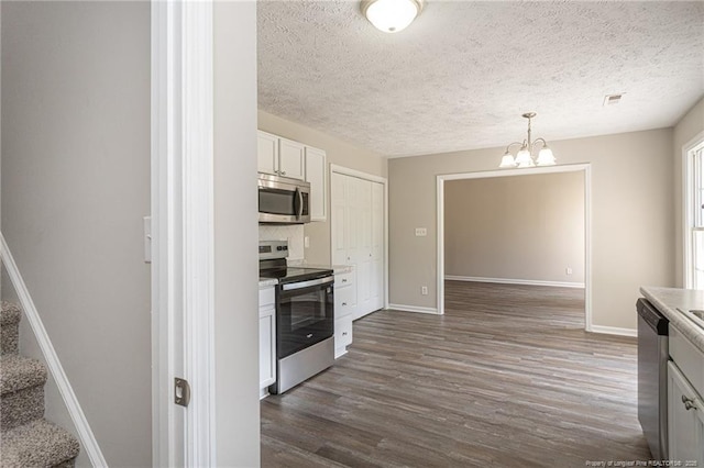 551 Hobson Rd, Raeford, NC 28376 - kitchen featuring appliances with stainless steel finishes, dark wood-type flooring, baseboards, a chandelier, and a textured ceiling