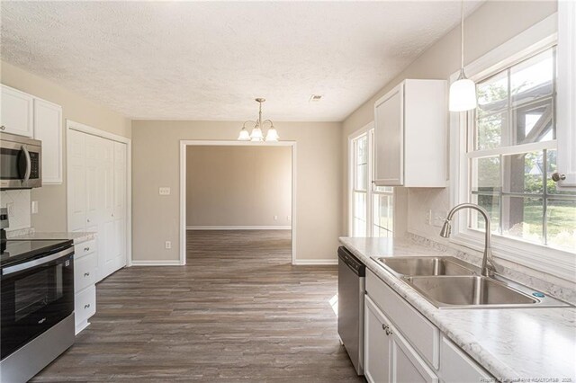 551 Hobson Rd, Raeford, NC 28376 - kitchen featuring stainless steel appliances, a sink, white cabinets, a chandelier, and baseboards