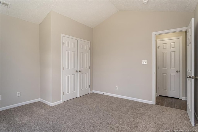 551 Hobson Rd, Raeford, NC 28376 - unfurnished bedroom featuring carpet floors, lofted ceiling, a closet, baseboards, and a textured ceiling