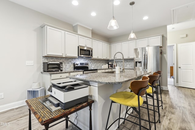 127 Manordale Dr, Chapel Hill, NC 27517 - kitchen featuring stainless steel appliances, a sink, decorative backsplash, baseboards, and a kitchen bar