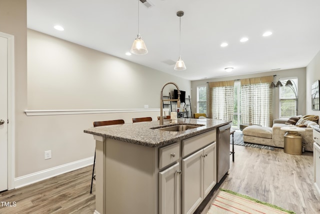 127 Manordale Dr, Chapel Hill, NC 27517 - kitchen featuring a sink, stainless steel dishwasher, light wood-type flooring, open floor plan, and light stone countertops