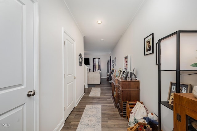 hall with wood finished floors, crown molding, and recessed lighting