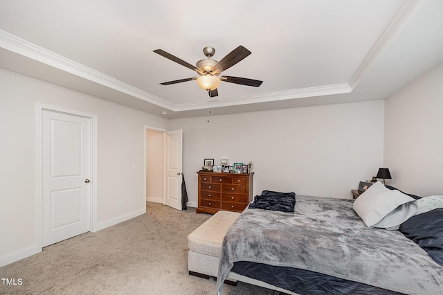 bedroom with a tray ceiling, crown molding, light colored carpet, baseboards, and ceiling fan