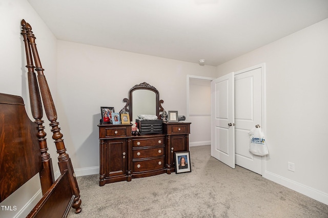 bedroom with light colored carpet and baseboards