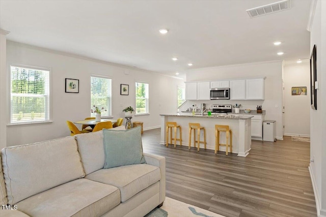 1440 Latham Garden Dr, Wake Forest, NC 27587 - living room with crown molding, light wood-type flooring, baseboards, and recessed lighting