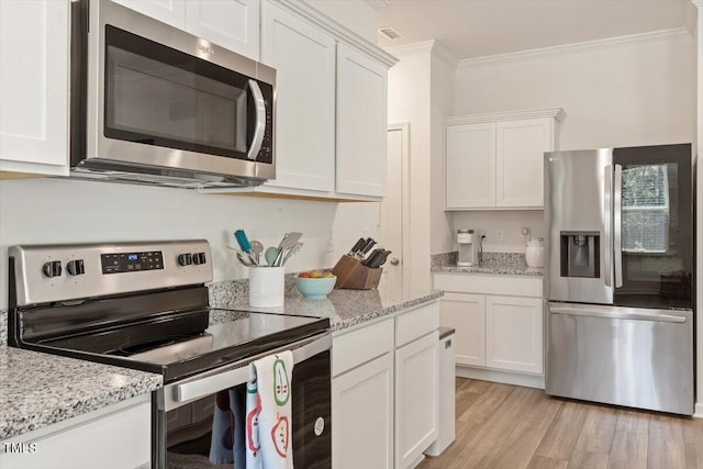 1440 Latham Garden Dr, Wake Forest, NC 27587 - kitchen with appliances with stainless steel finishes, ornamental molding, white cabinetry, light wood-style flooring, and light stone countertops