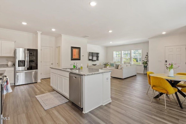 1440 Latham Garden Dr, Wake Forest, NC 27587 - kitchen featuring stainless steel appliances, a sink, white cabinetry, ornamental molding, and a kitchen island with sink