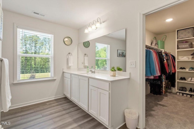 1440 Latham Garden Dr, Wake Forest, NC 27587 - bathroom with vanity, a walk in closet, baseboards, wood finished floors, and recessed lighting