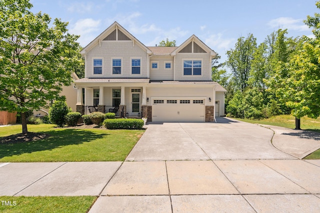 craftsman inspired home with covered porch, a front yard, concrete driveway, a garage, and stone siding
