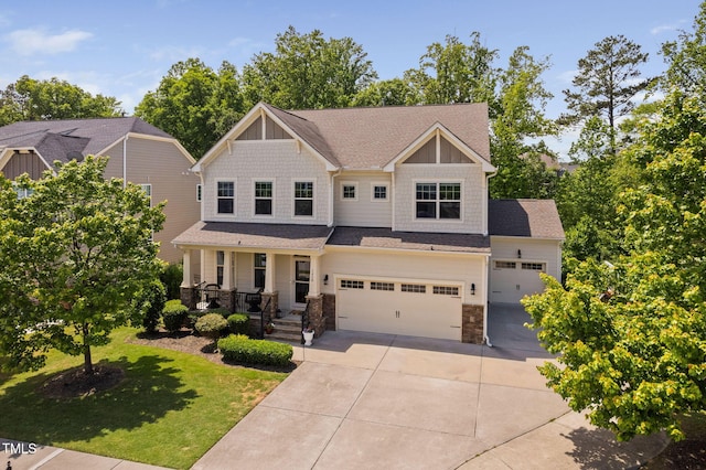 craftsman inspired home with concrete driveway, a porch, stone siding, a front lawn, and roof with shingles