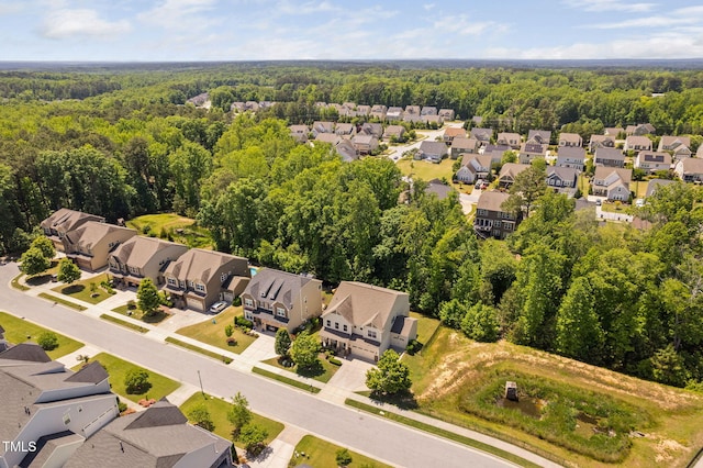 aerial perspective of suburban area featuring a heavily wooded area