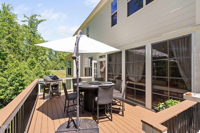 wooden deck with outdoor dining area and a grill