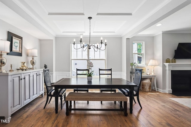 dining space with a chandelier, coffered ceiling, wood finished floors, beamed ceiling, and a fireplace with flush hearth