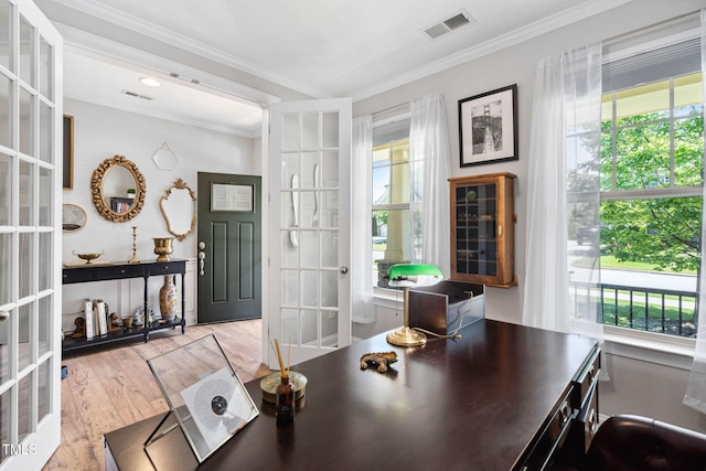 office with french doors, healthy amount of natural light, wood finished floors, and ornamental molding