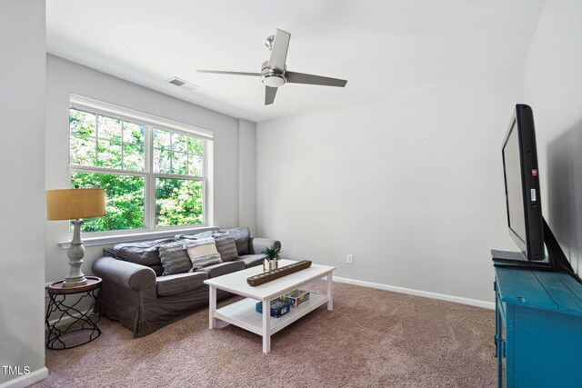 living area with ceiling fan, carpet floors, and baseboards