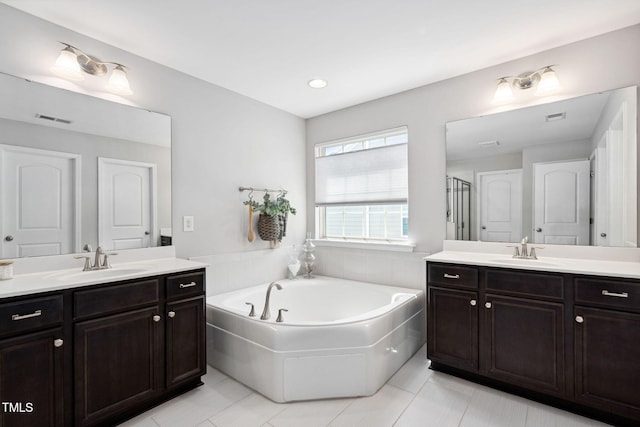 full bathroom with two vanities, tile patterned floors, a garden tub, and recessed lighting