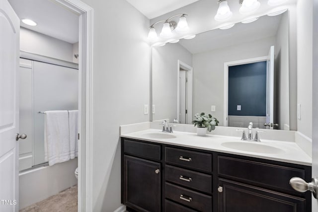 bathroom with double vanity, toilet, and enclosed tub / shower combo