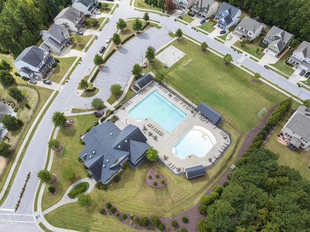 view of property location featuring a pool and nearby suburban area