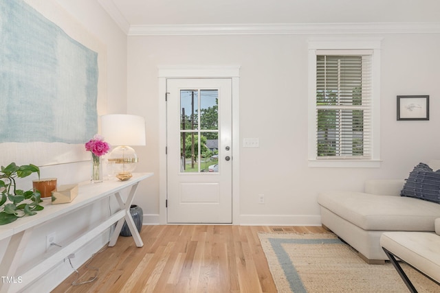 foyer featuring ornamental molding, light wood-style flooring, and baseboards