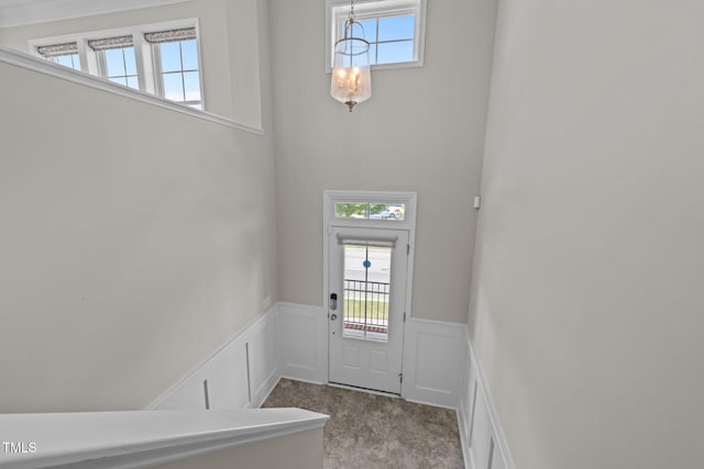 986 Gateway Commons Cir, Wake Forest, NC 27587 - doorway to outside with carpet flooring, a chandelier, wainscoting, healthy amount of natural light, and a decorative wall