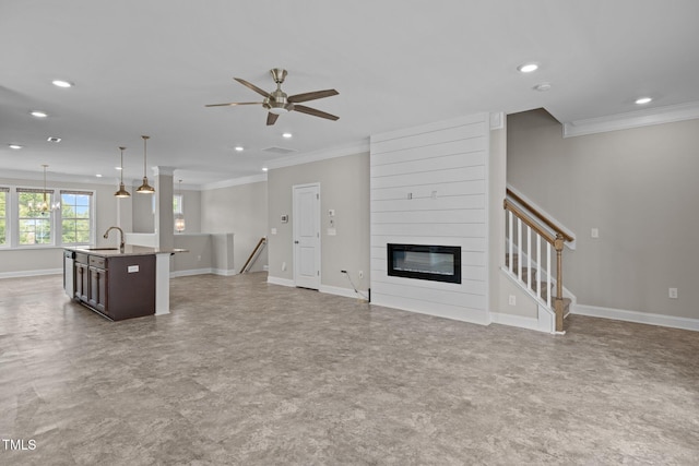 986 Gateway Commons Cir, Wake Forest, NC 27587 - unfurnished living room featuring a sink, ornamental molding, a ceiling fan, baseboards, and a large fireplace