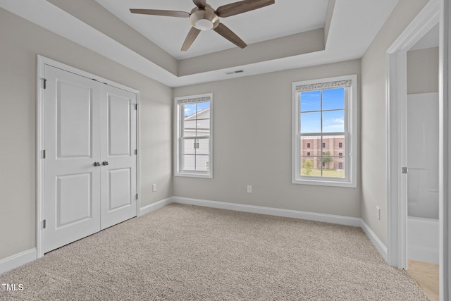 986 Gateway Commons Cir, Wake Forest, NC 27587 - unfurnished bedroom with light colored carpet, baseboards, a closet, and a tray ceiling