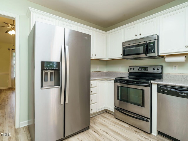 253 Middle Landing Dr, Smithfield, NC 27577 - kitchen with stainless steel appliances, light wood-style flooring, and white cabinetry