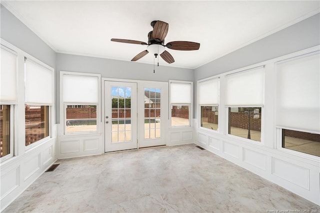 unfurnished sunroom featuring a ceiling fan and ornamental molding