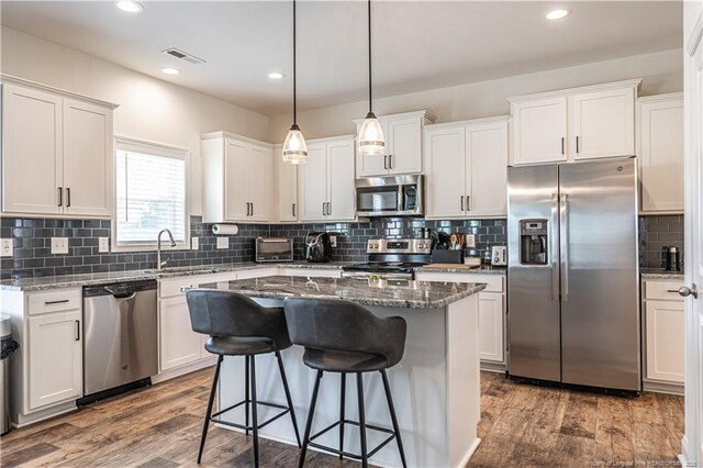 527 Weston Woods St, Raeford, NC 28376 - kitchen featuring stainless steel appliances, a sink, a kitchen bar, white cabinets, and tasteful backsplash