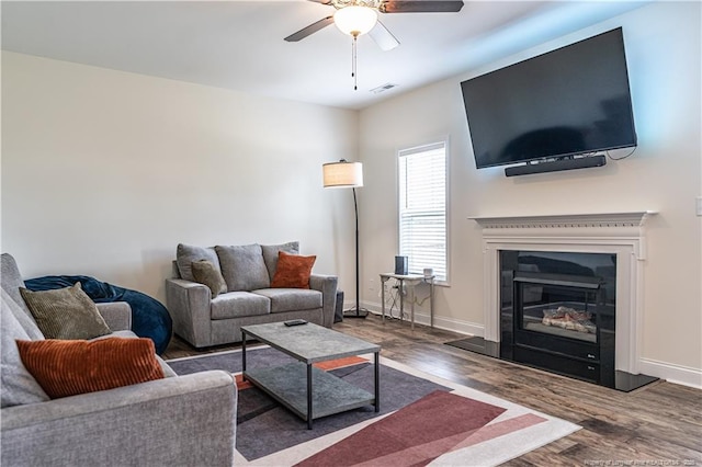 527 Weston Woods St, Raeford, NC 28376 - living room with ceiling fan, wood finished floors, a glass covered fireplace, and baseboards