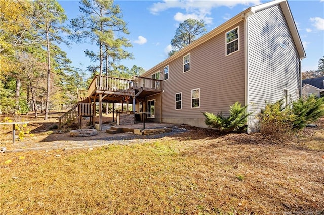 back of house with a wooden deck, a patio, and stairs