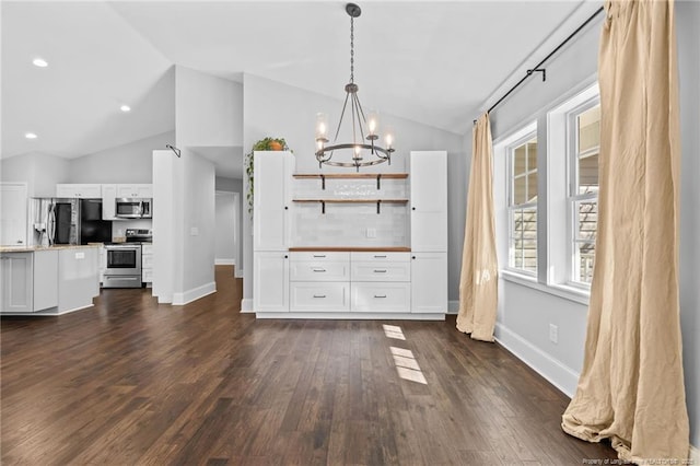 dining space with vaulted ceiling, a chandelier, dark wood-type flooring, and baseboards