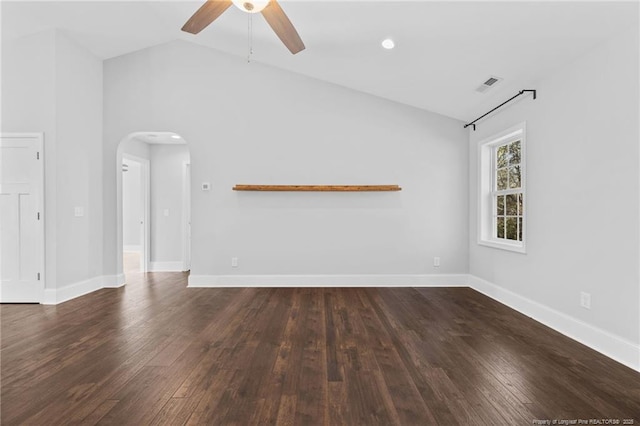 unfurnished living room featuring vaulted ceiling, ceiling fan, arched walkways, dark wood-style floors, and baseboards