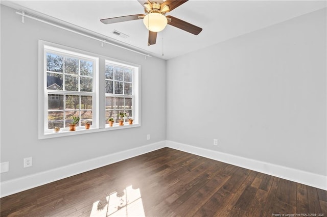 spare room featuring dark wood finished floors, baseboards, and ceiling fan