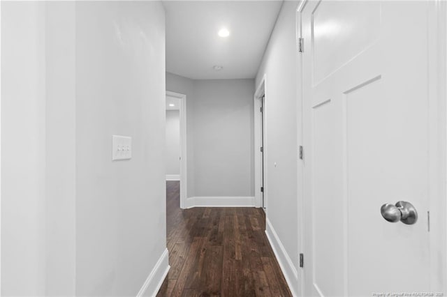 hallway featuring dark wood finished floors, baseboards, and recessed lighting